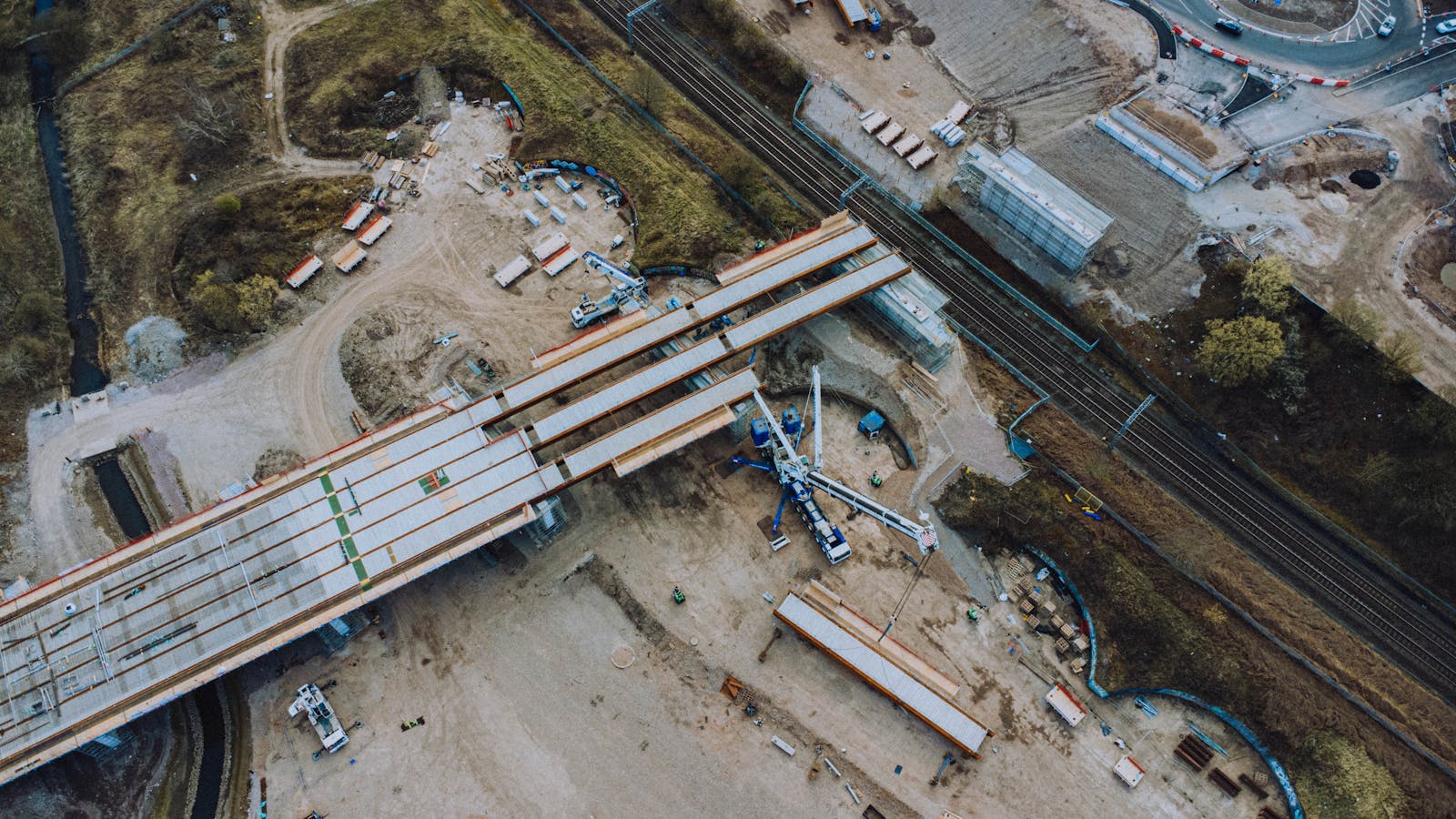 Aerial view of bridge construction site with cranes and equipment