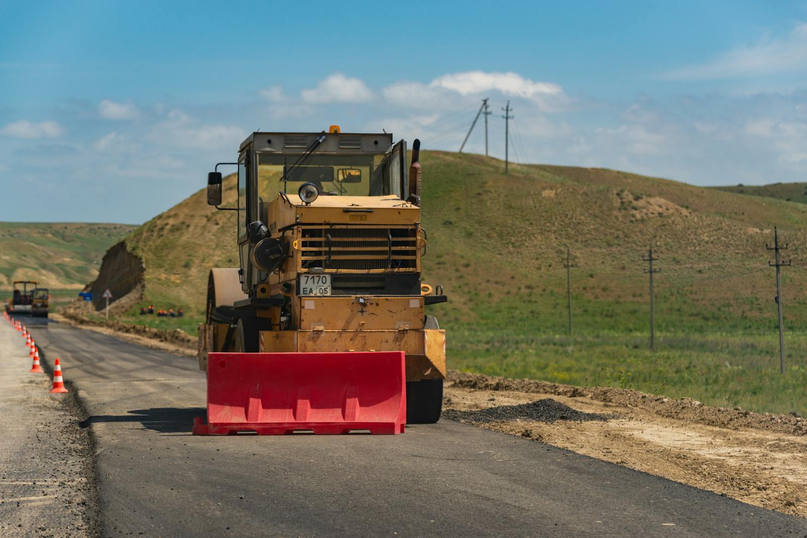 Road roller compacting fresh asphalt on a rural roadway